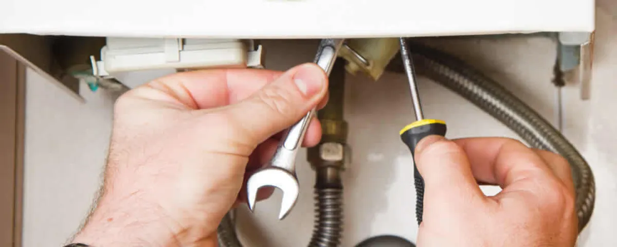 Boiler repair technician tightening pipe fittings and connections in Billings, MT