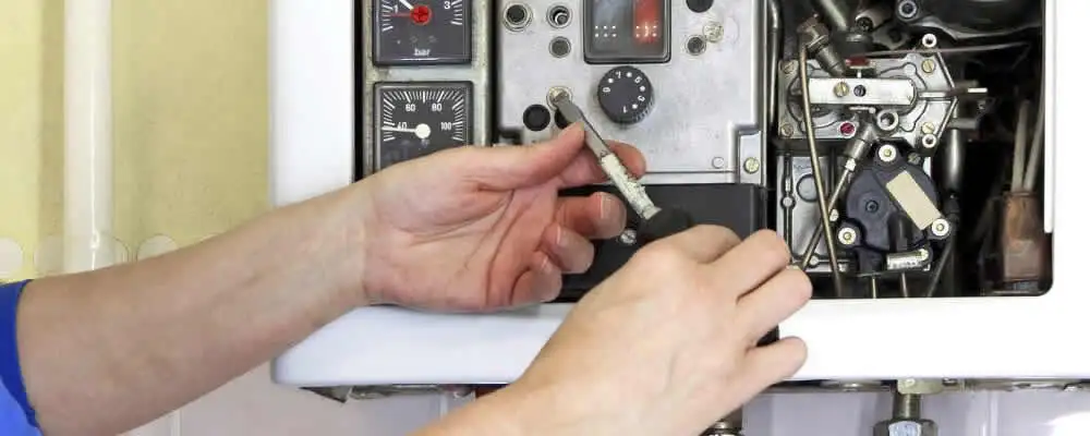 Heating repair technician adjusting boiler controls and components in Billings, MT
