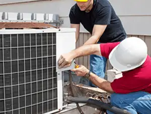 HVAC technicians repairing an outdoor AC unit on a rooftop in Billings, MT