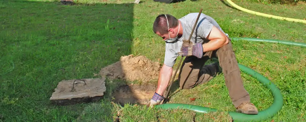 Septic pumping technician servicing a residential septic tank in Billings, MT