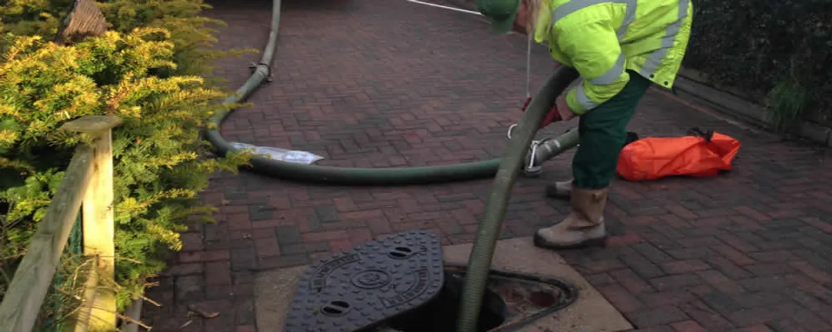 Septic tank cleaning technician servicing a septic tank with a vacuum hose in Billings, MT